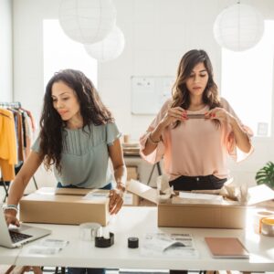 Two people packing boxes for customer orders